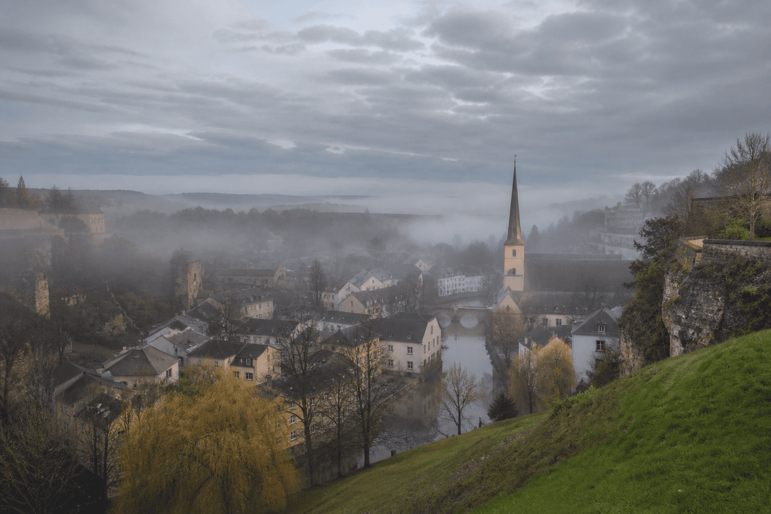 Tal mit Häusern und leichtem Nebel in Luxemburg am Morgen